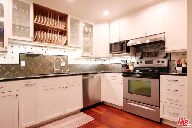 a kitchen with stainless steel appliances granite countertop a sink and a stove