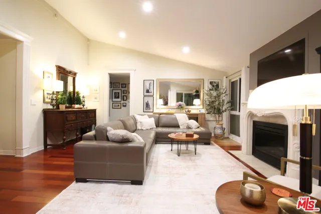 a living room with furniture a flat screen tv and a fireplace