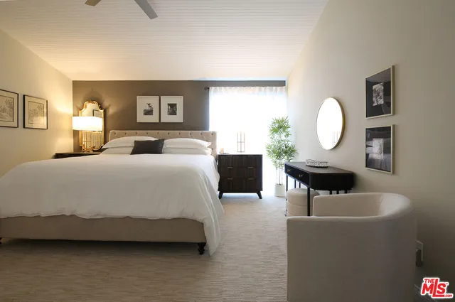 a spacious bedroom with a bed a mirror and a window