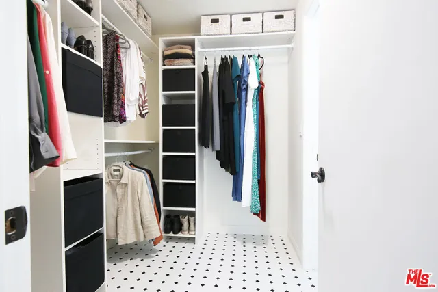 a view of walk in closet with clothes and shoes