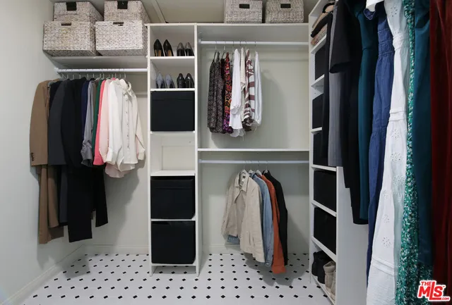a view of walk in closet with clothes and shoes