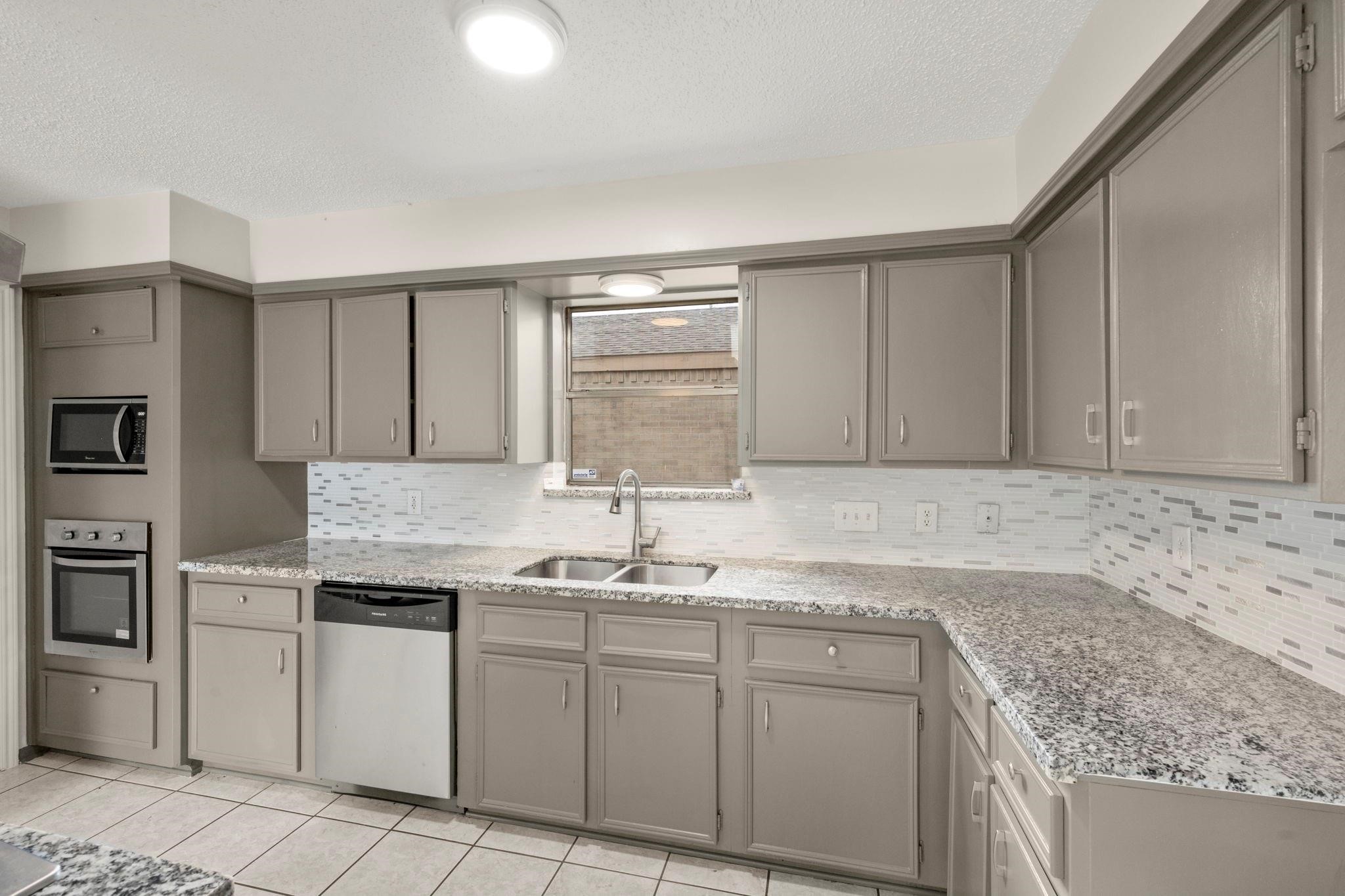 11718 Ridge Run Drive Houston, TX 77064 - Photo 3 of 17 a kitchen with granite countertop cabinets sink and stove