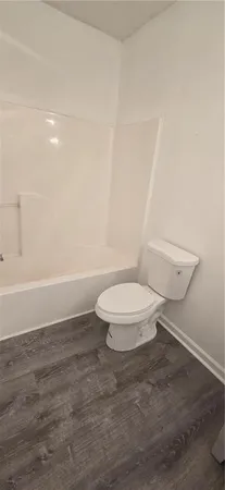a white toilet sitting next to a shower