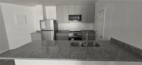 a kitchen with kitchen island a sink stove and refrigerator