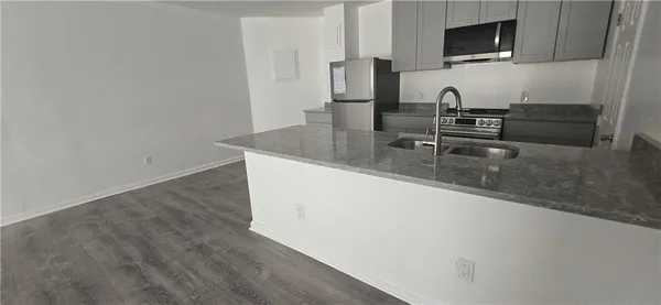 a kitchen with granite countertop a sink and a stove top oven