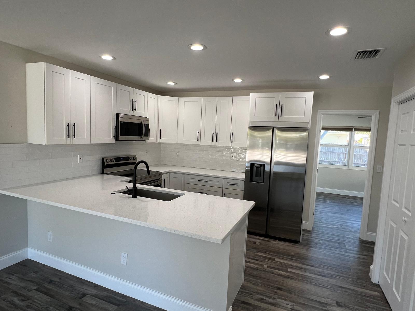 1625 North M Street Lake Worth Beach, FL 33460 - Photo 5 of 23 a kitchen with refrigerator cabinets and wooden floor
