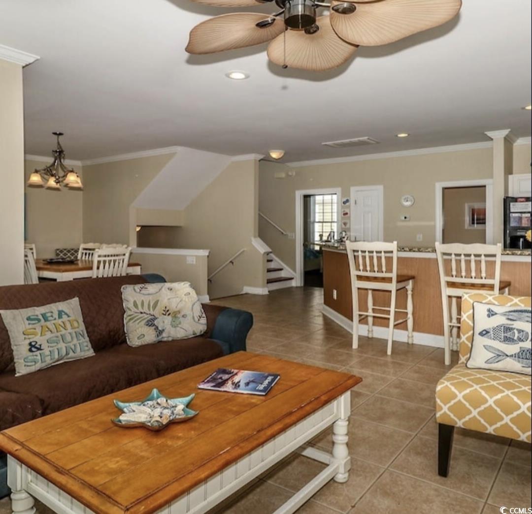 511 Caribbean Way Myrtle Beach, SC 29577 - Photo 3 of 17 Living room with tile patterned flooring, ceiling fan with notable chandelier, and ornamental molding