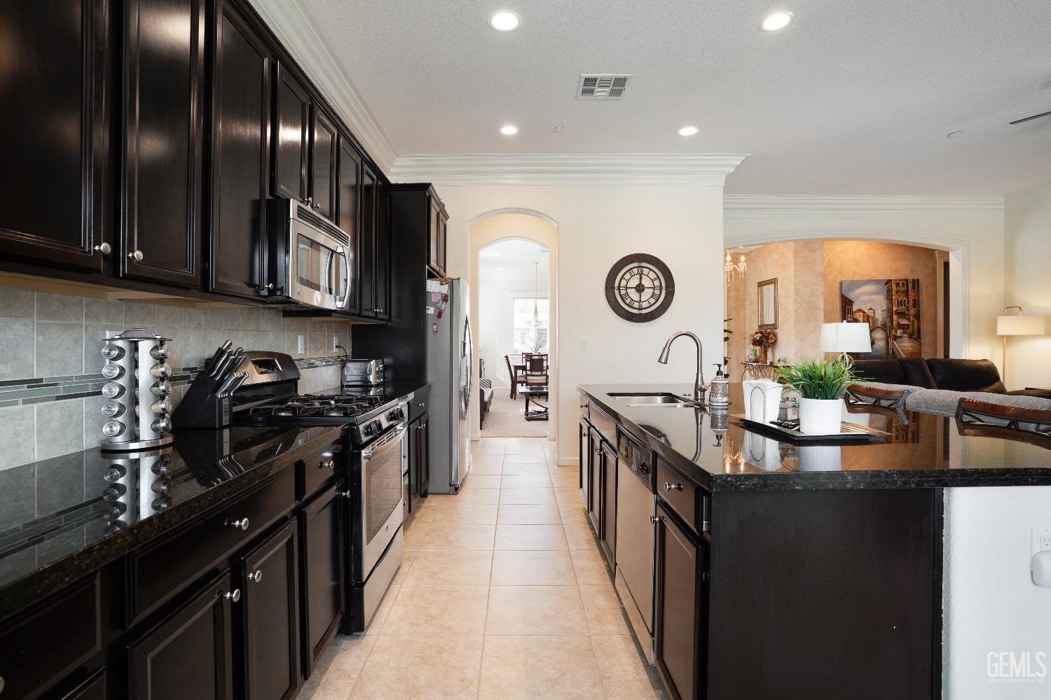 Undisclosed Address Bakersfield, CA 93314 - Photo 12 of 42 a kitchen with granite countertop a sink stove top oven and cabinets