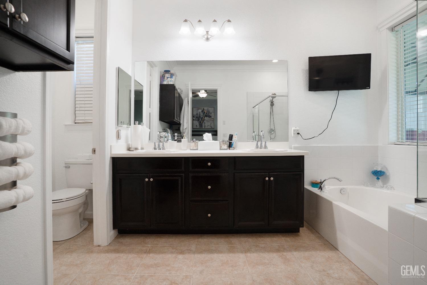 Undisclosed Address Bakersfield, CA 93314 - Photo 35 of 42 a bathroom with a double vanity sink a mirror and a toilet