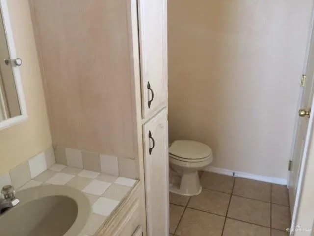 a bathroom with a granite countertop toilet a sink and a mirror