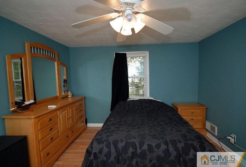 117 2nd Street Dunellen, NJ 08812 - Photo 19 of 25 a bedroom with a bed and a flat tv screen on dresser