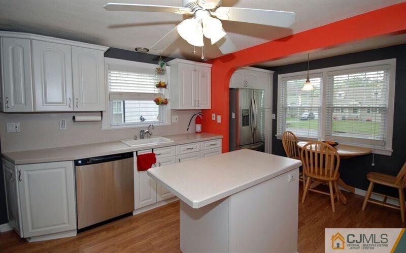 117 2nd Street Dunellen, NJ 08812 - Photo 8 of 25 a kitchen with a stove a refrigerator and a dining table