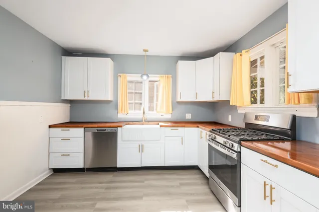 a kitchen with stainless steel appliances a white stove top oven sink and cabinets