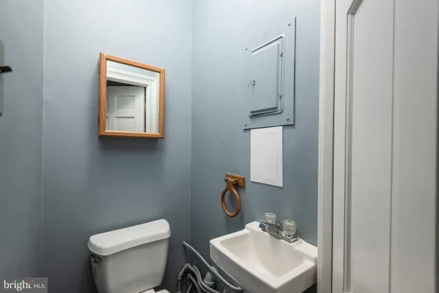 a bathroom with a toilet sink and mirror