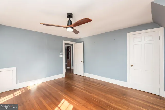 a view of room with wooden floor and ceiling fan