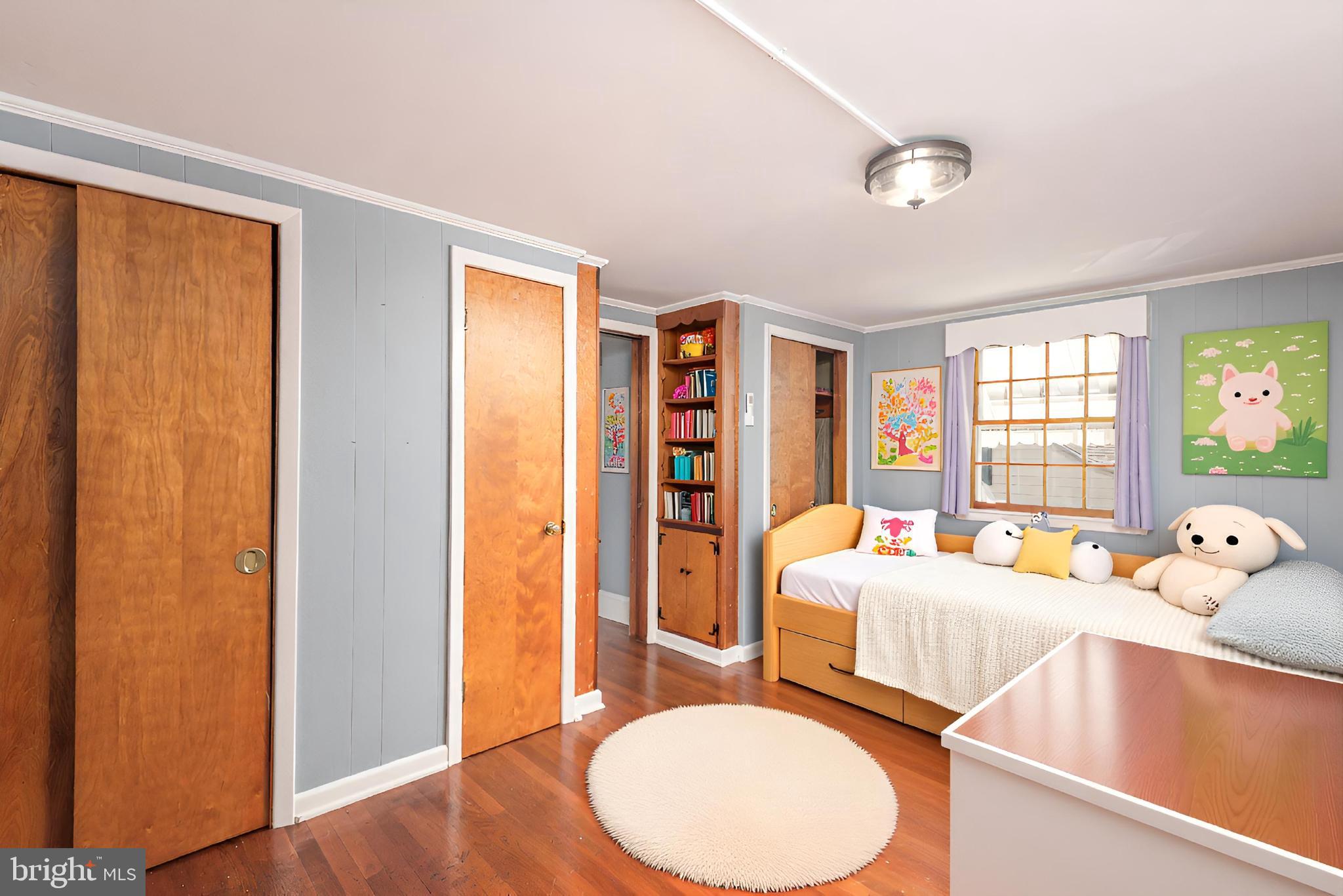 107 Rambler Road Cambridge, MD 21613 - Photo 22 of 28 a bedroom with a bed and wooden floor