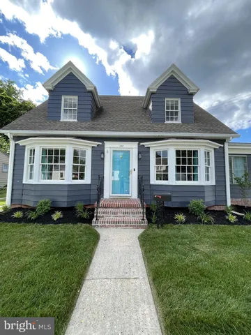 a front view of a house with a yard and outdoor seating