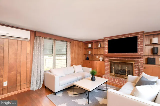 a living room with furniture a flat screen tv and a fireplace