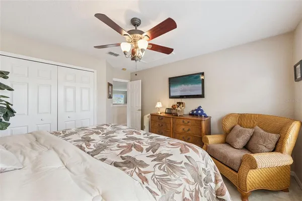 a spacious bedroom with a bed and a flat screen tv