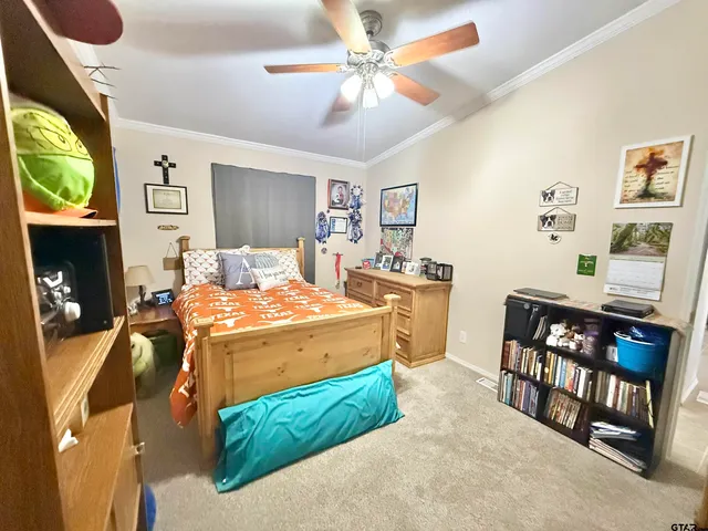 a bedroom with a bed a dresser and potted plants