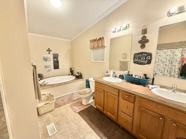 a spacious bathroom with a double vanity sink mirror and bathtub