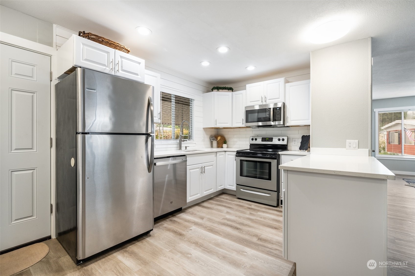 2302 R Street Southeast, Unit 12 Auburn, WA 98002 - Photo 6 of 34 a kitchen with a refrigerator a stove top oven a sink and cabinets