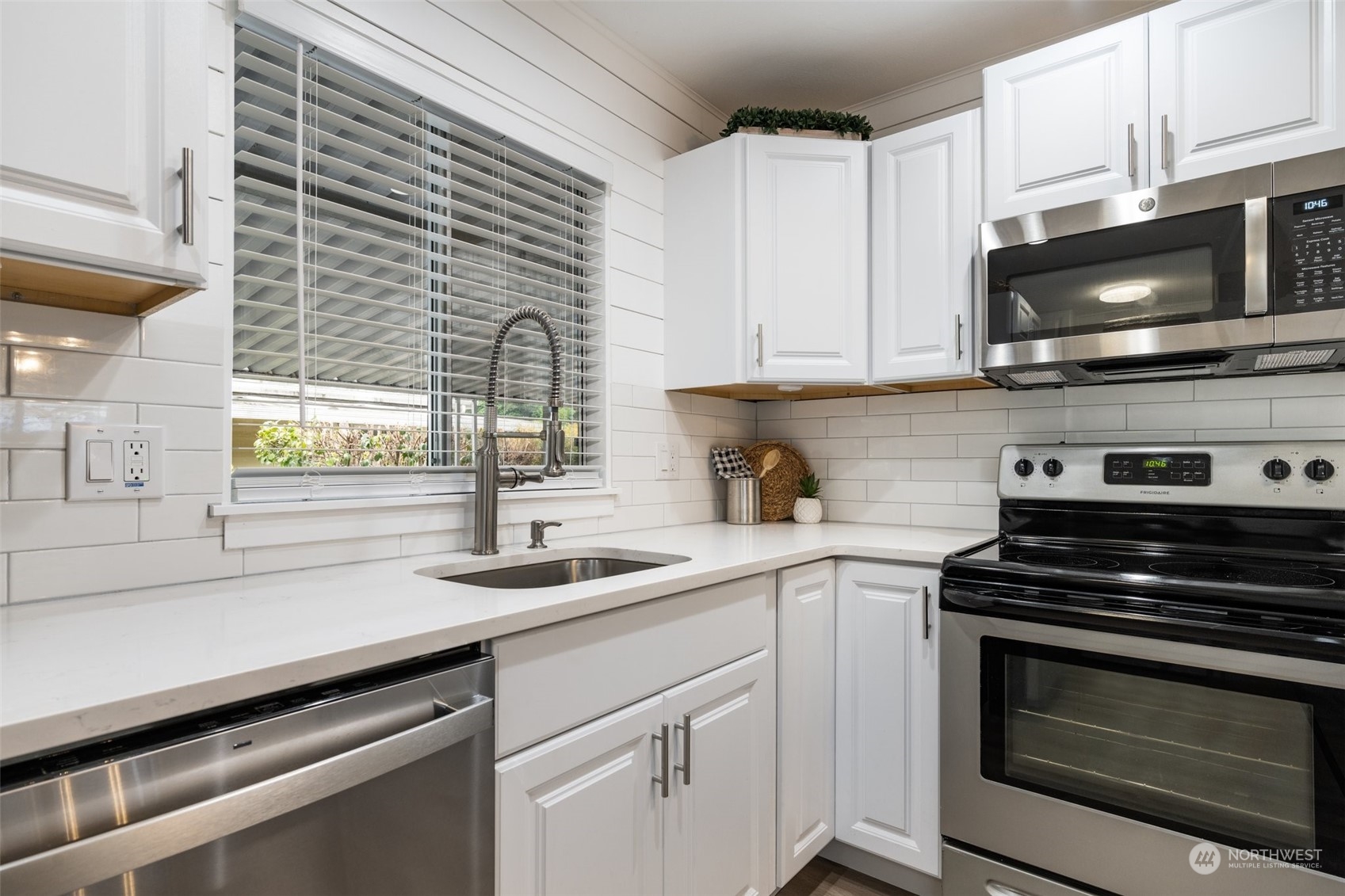2302 R Street Southeast, Unit 12 Auburn, WA 98002 - Photo 8 of 34 a kitchen with stainless steel appliances a stove microwave and sink