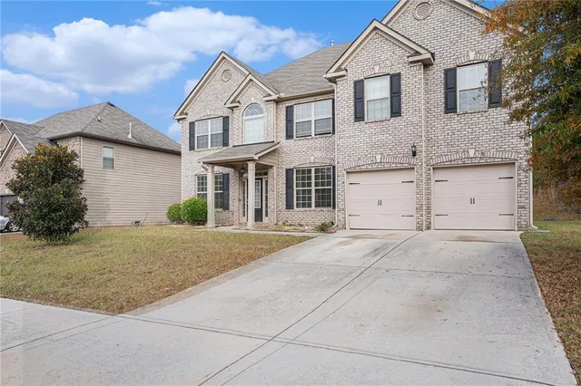 a front view of a house with a yard and garage