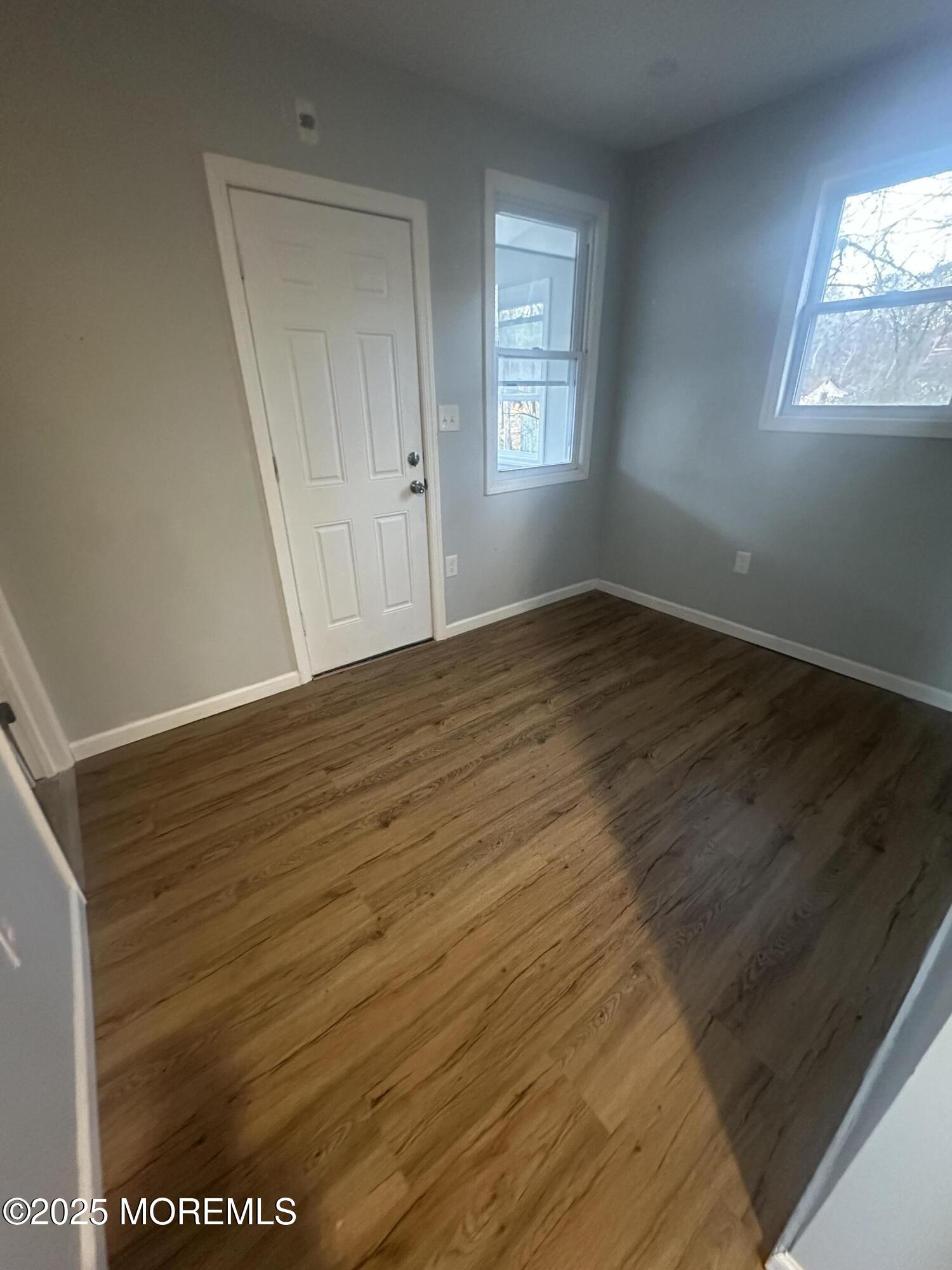 240 Perrineville Road Jackson, NJ 08527 - Photo 11 of 12 a view of an empty room with wooden floor and a window
