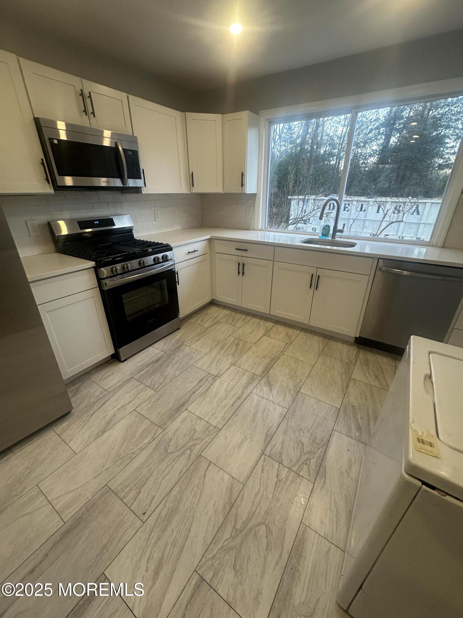 240 Perrineville Road Jackson, NJ 08527 - Photo 4 of 12 a kitchen with stainless steel appliances granite countertop a sink a stove a microwave a counter top and cabinets