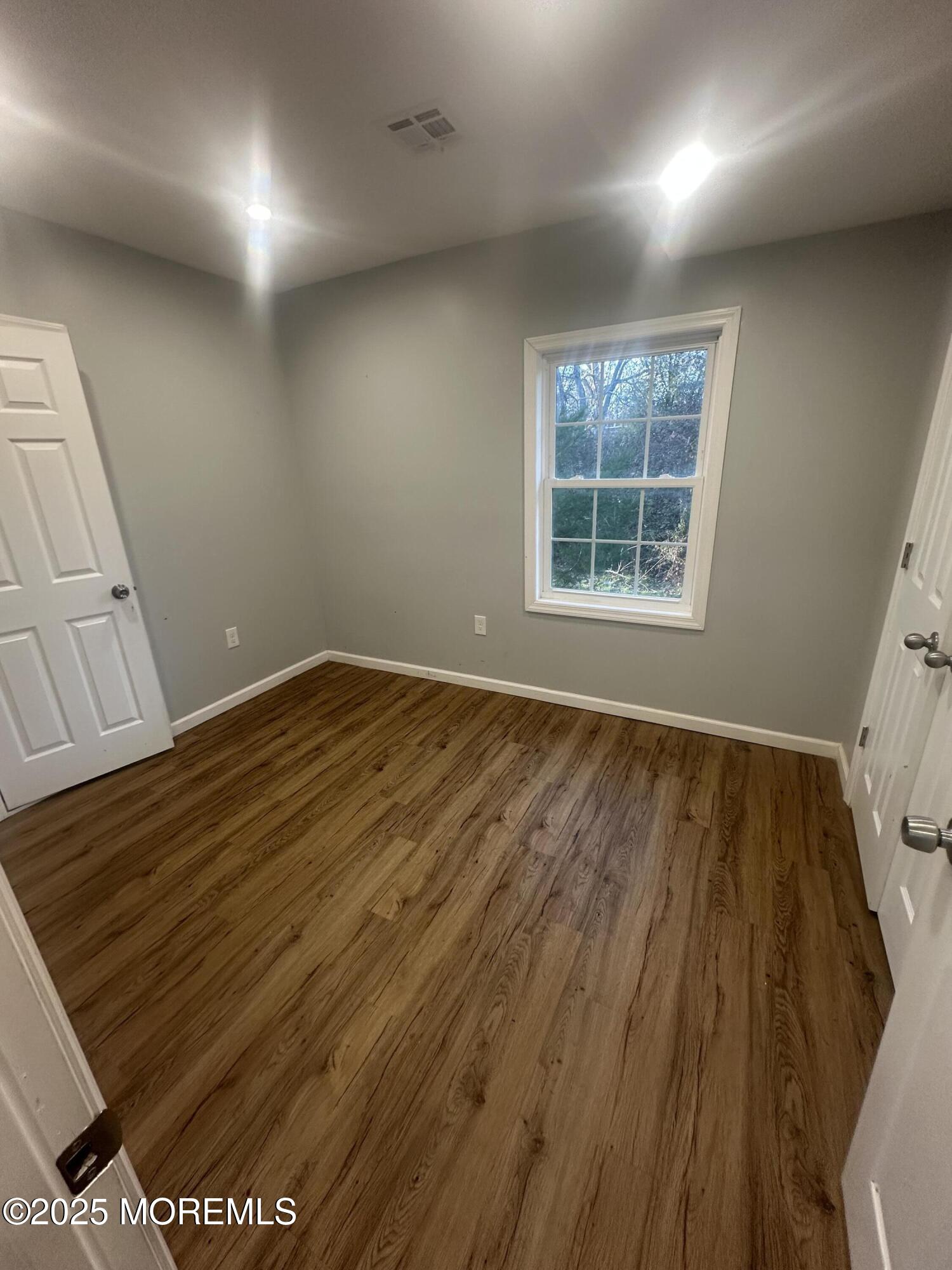 240 Perrineville Road Jackson, NJ 08527 - Photo 8 of 12 an empty room with wooden floor and windows