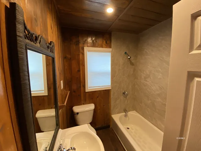 an empty room with a ceiling fan and a window