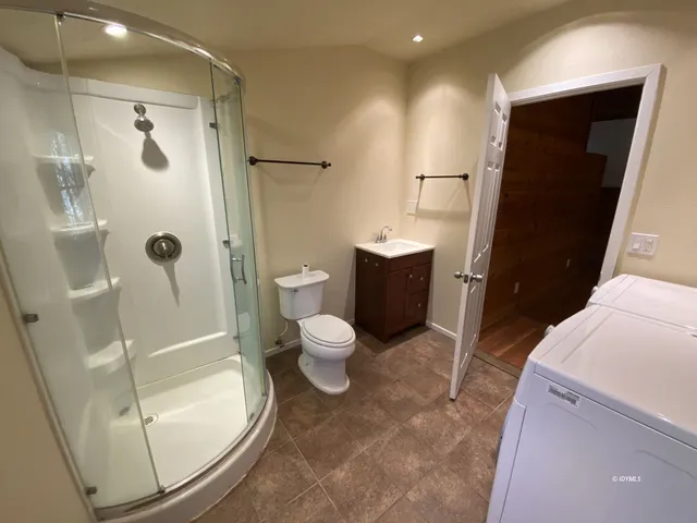a bathroom with a sink a toilet a mirror and shower