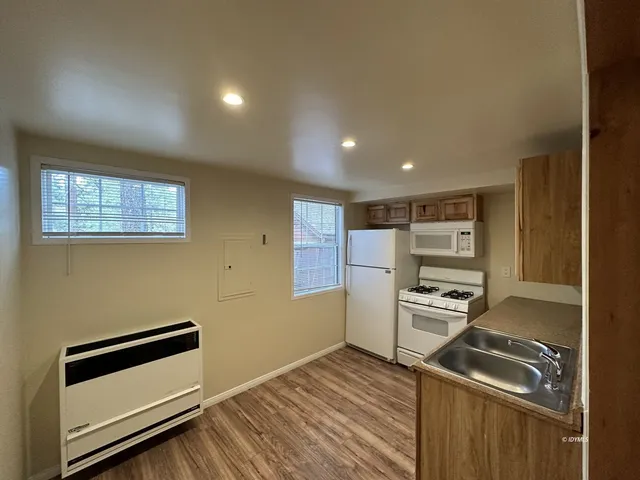 a very nice looking room with wooden floor and furniture