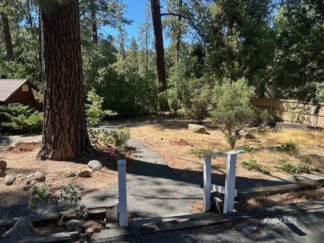 a view of a house with a tree and wooden fence