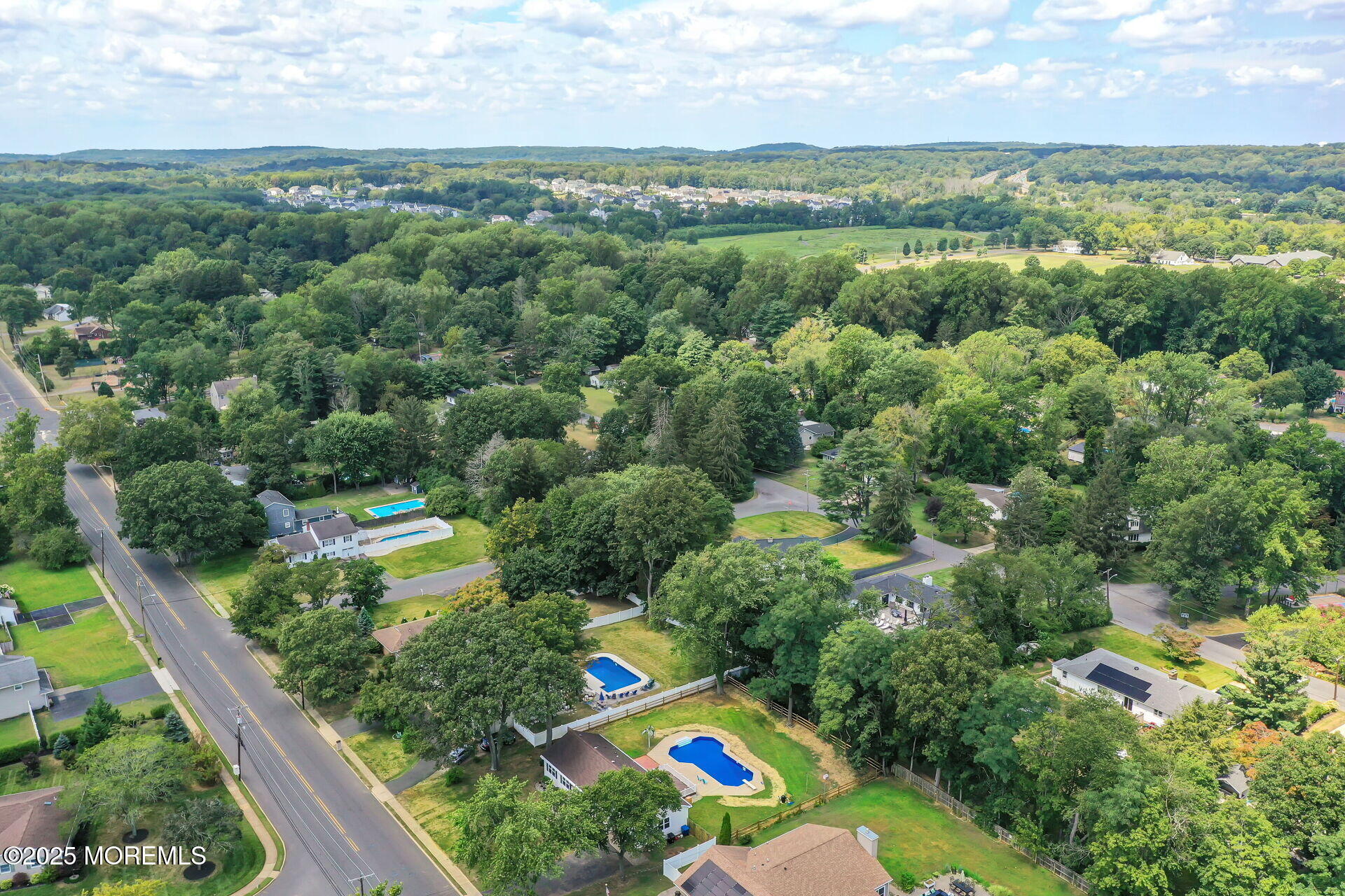 1276 West Front Street Lincroft, NJ 07738 - Photo 59 of 66 an aerial view of green landscape with trees houses and mountain view