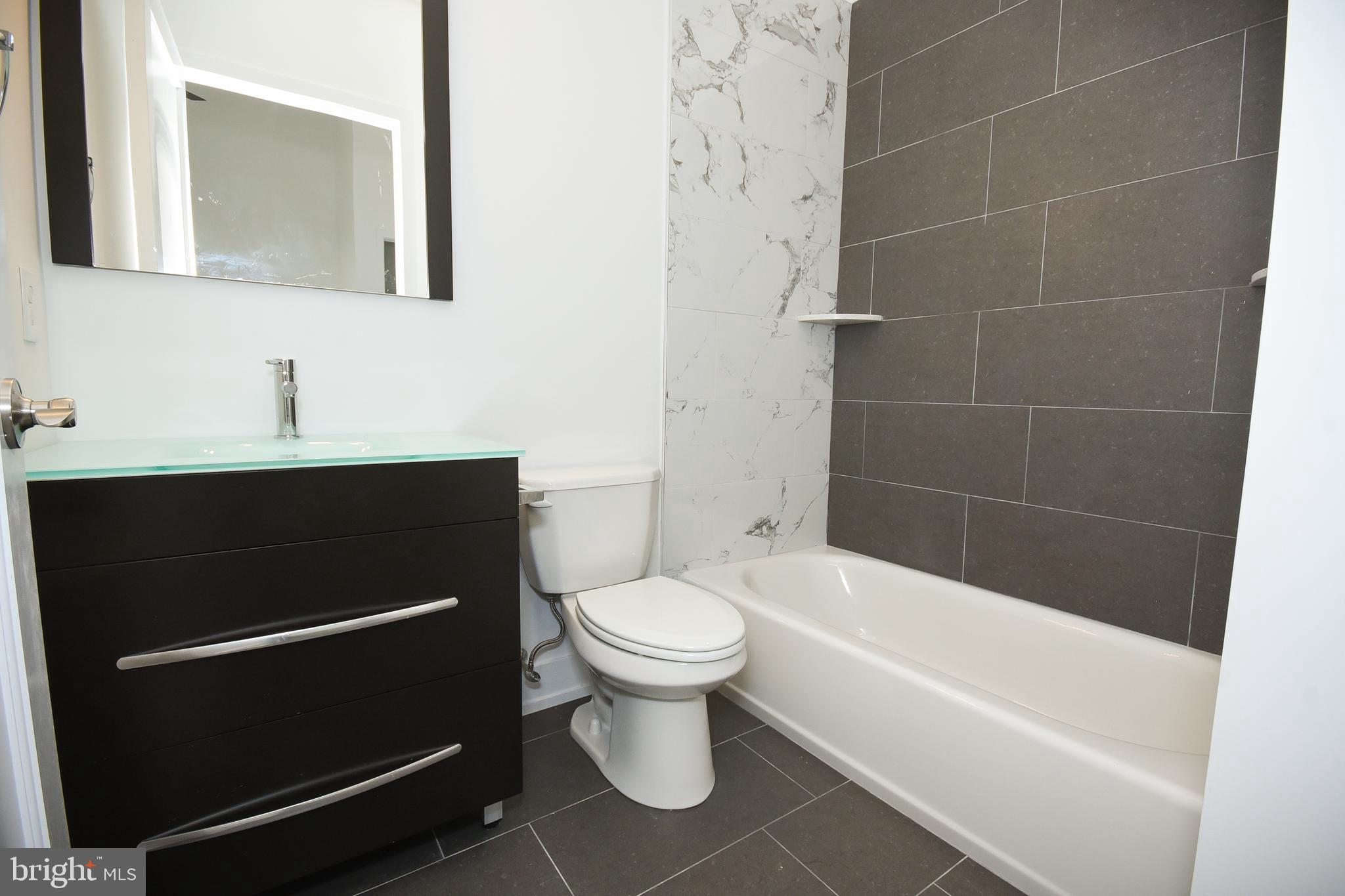 6162 Ridge Avenue, Unit 203 Philadelphia, PA 19128 - Photo 15 of 20 a bathroom with a sink a toilet and shower