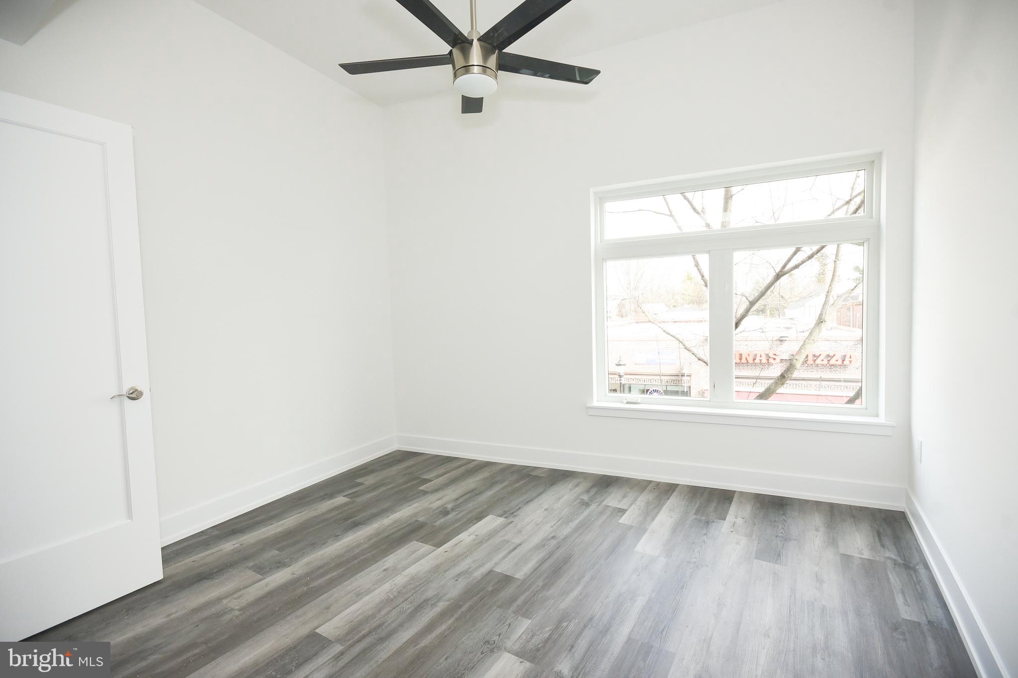 6162 Ridge Avenue, Unit 203 Philadelphia, PA 19128 - Photo 18 of 20 an empty room with wooden floor fan and windows