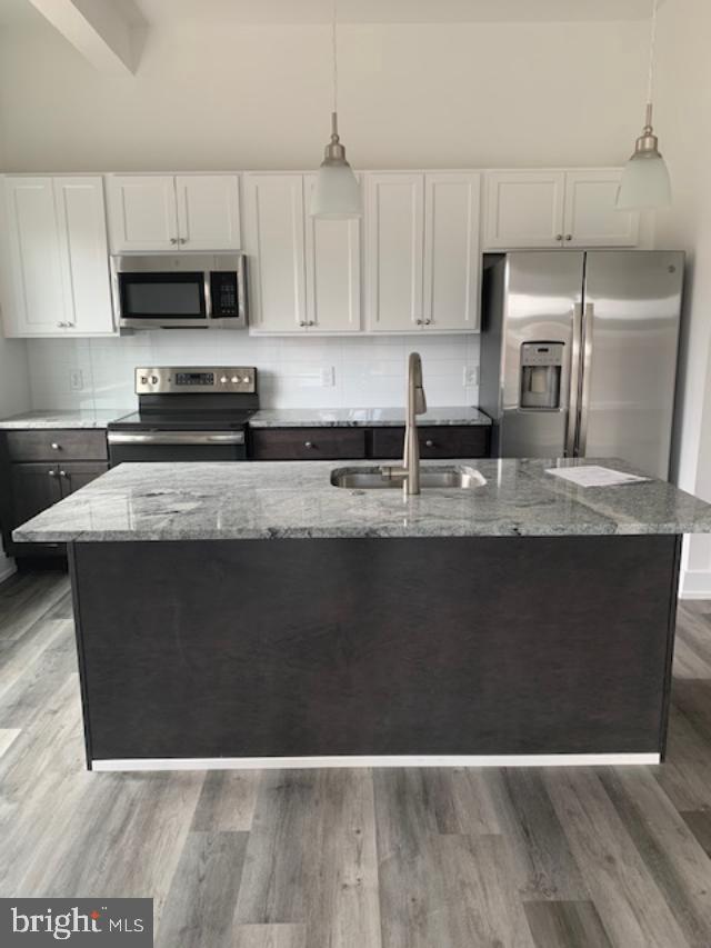 6162 Ridge Avenue, Unit 203 Philadelphia, PA 19128 - Photo 9 of 20 a kitchen with stainless steel appliances granite countertop a stove a sink and a microwave