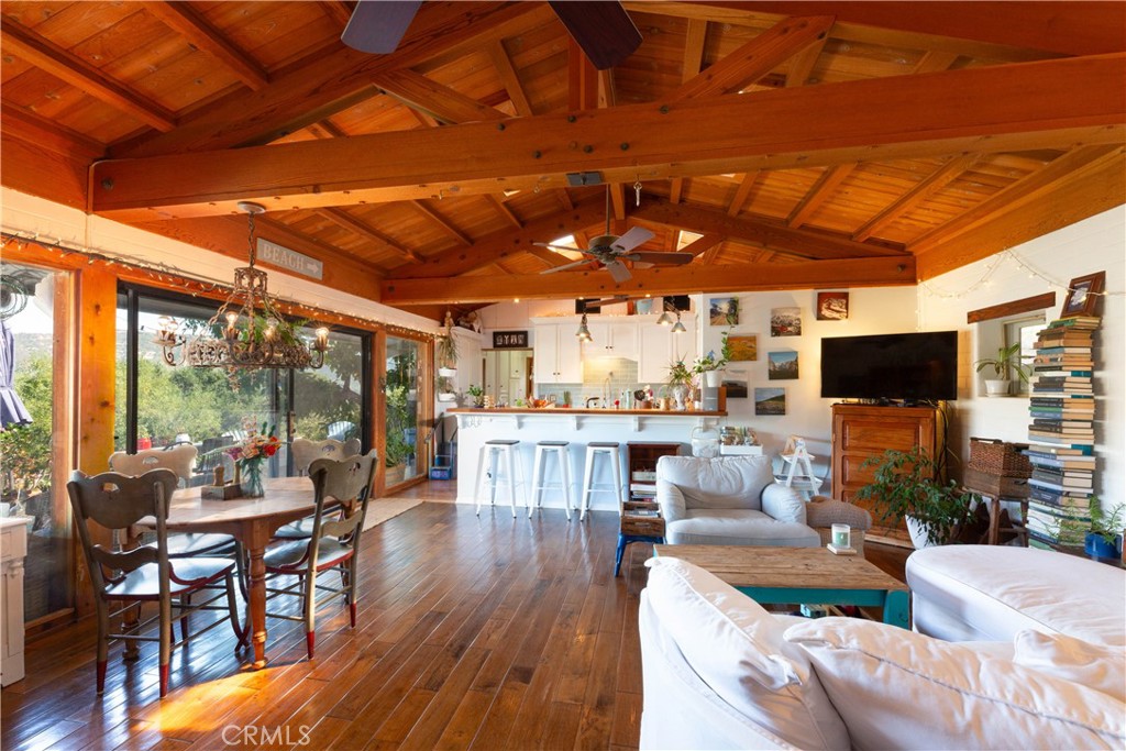 a living room with furniture a flat screen tv and floor to ceiling window