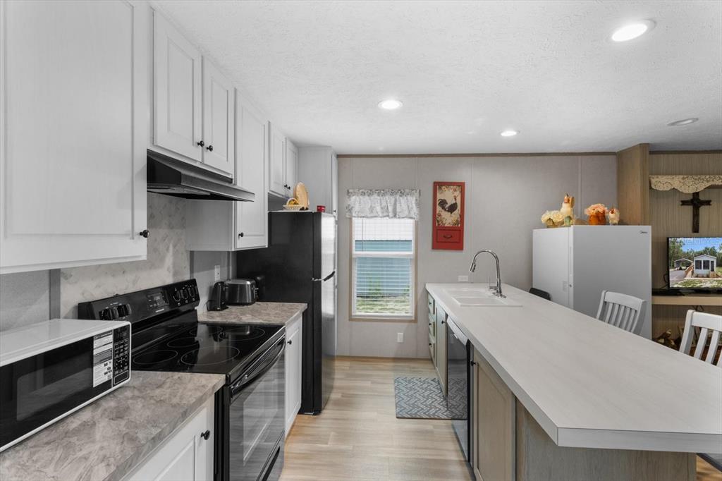 4686 C R 656 Webster, FL 33597 - Photo 10 of 32 a kitchen with stainless steel appliances a stove a refrigerator a sink a stove and wooden cabinets