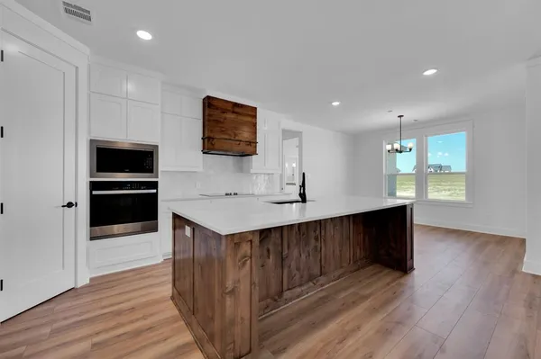 a kitchen with stainless steel appliances a kitchen island hardwood floor sink and stove