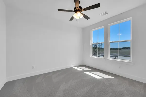 an empty room with a window and a fan