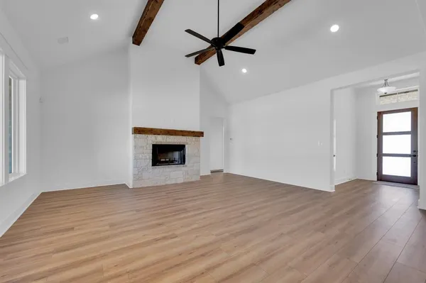 a view of an empty room with a fireplace and a window