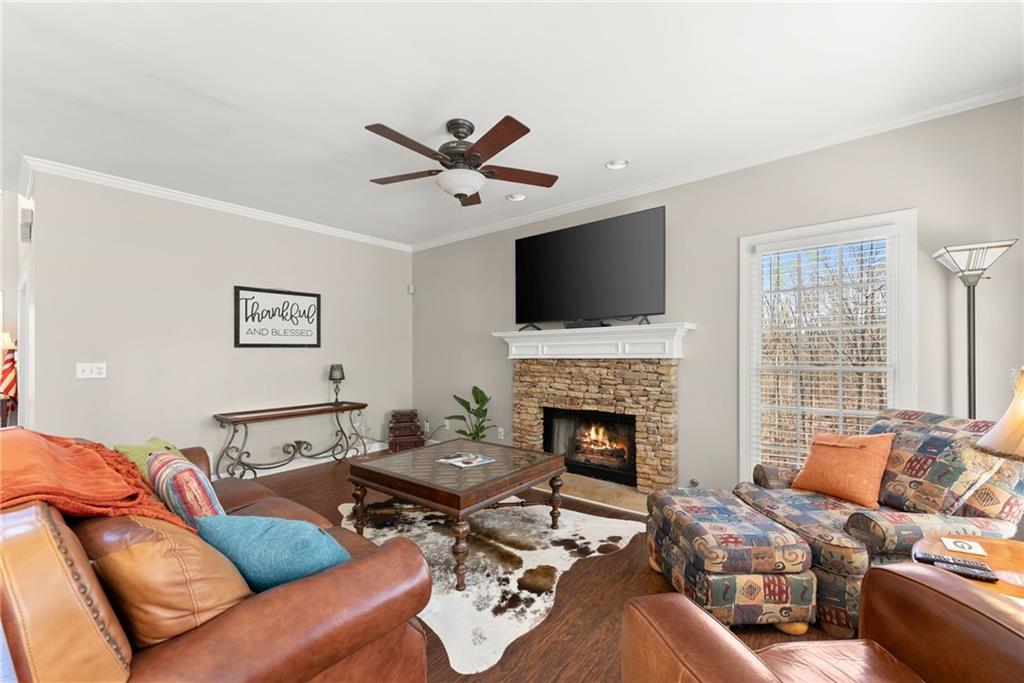 4834 Upper Berkshire Road Flowery Branch, GA 30542 - Photo 16 of 76 a living room with furniture a fireplace and a flat screen tv