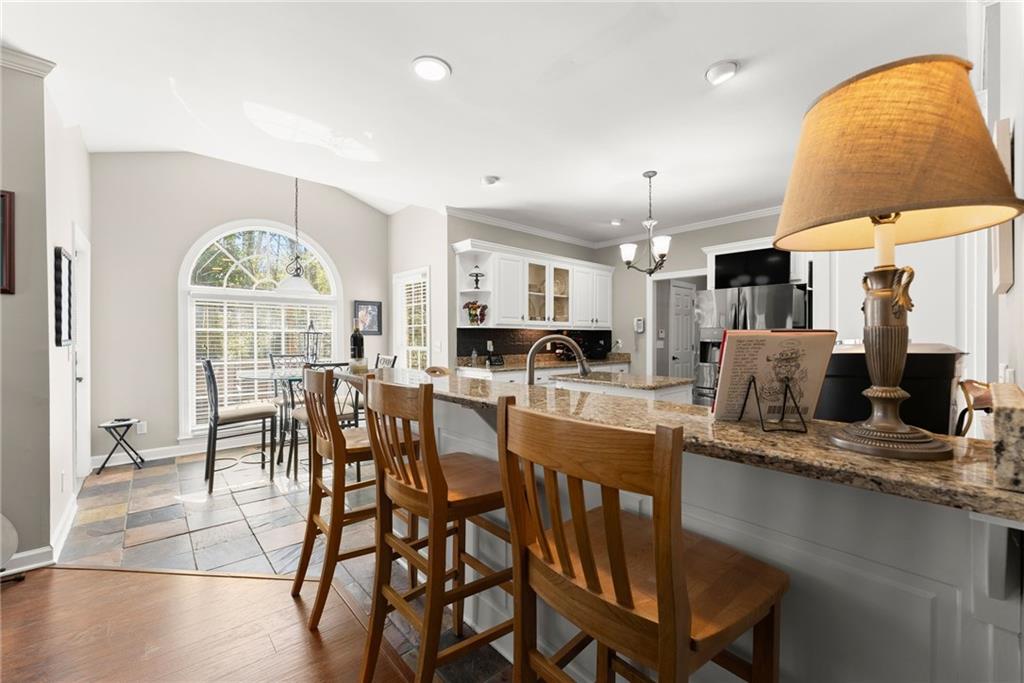 4834 Upper Berkshire Road Flowery Branch, GA 30542 - Photo 18 of 76 a kitchen with stainless steel appliances granite countertop a table and chairs in it