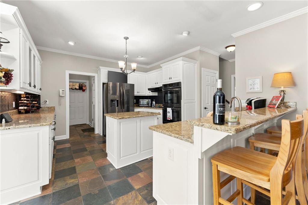 4834 Upper Berkshire Road Flowery Branch, GA 30542 - Photo 19 of 76 a kitchen with kitchen island a sink stainless steel appliances and cabinets