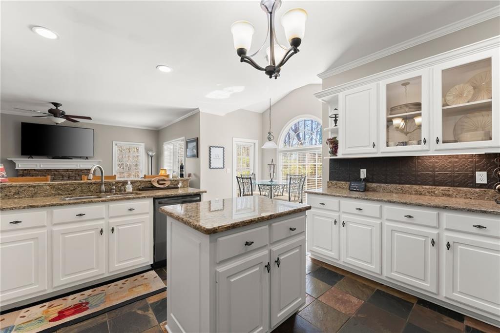 4834 Upper Berkshire Road Flowery Branch, GA 30542 - Photo 21 of 76 a kitchen with granite countertop a sink white cabinets and stainless steel appliances