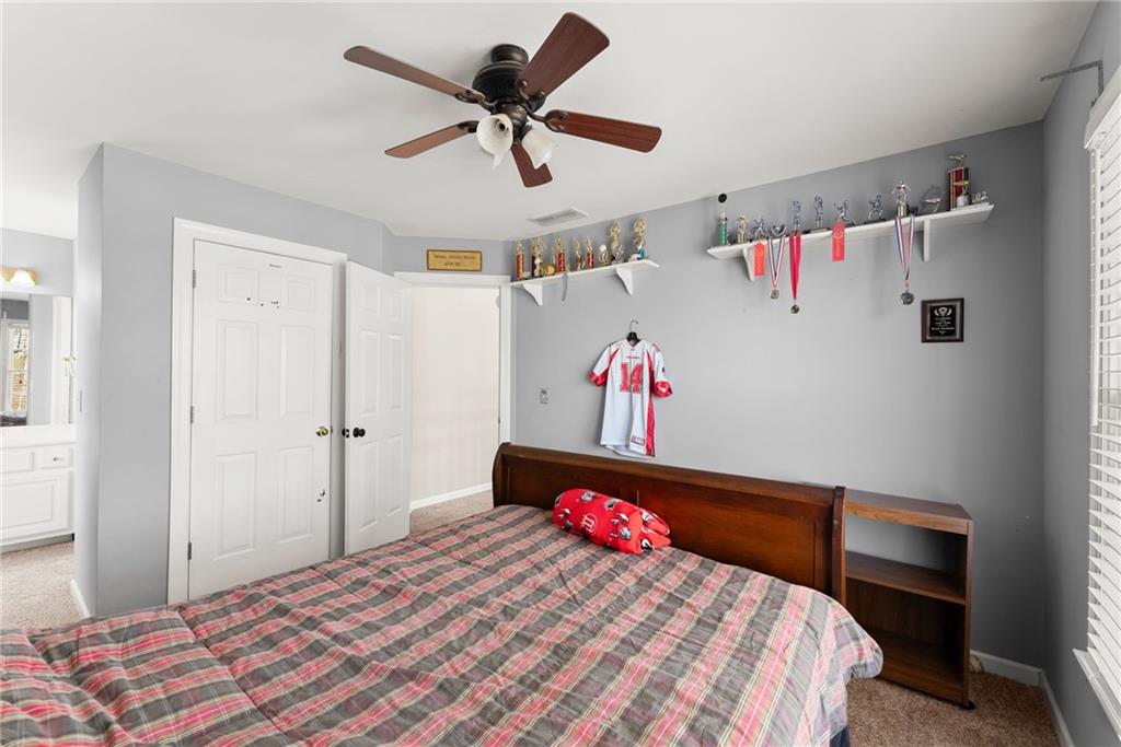 4834 Upper Berkshire Road Flowery Branch, GA 30542 - Photo 36 of 76 a bedroom with a bed and a chandelier