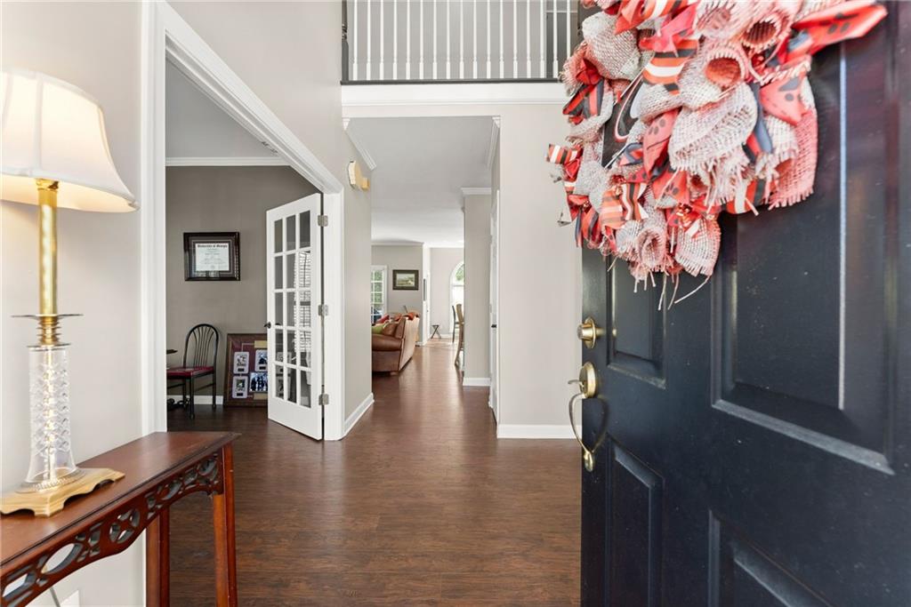 4834 Upper Berkshire Road Flowery Branch, GA 30542 - Photo 10 of 76 a view of a hallway with wooden floor and a living room